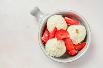 Vanilla ice cream with fresh organic strawberry and coconut flakes. Isolated on white background.