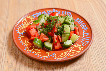Appetizing salad with vegetables, tomatoes and cucumbers. Ukrainian cuisine concept, food in Ukraine.