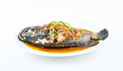 A dish of Cantonese steamed grouper on white background
