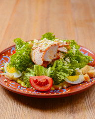 Appetizing salad with vegetables, meat and fresh greenery. Caesar salad. Ukrainian cuisine concept, food in Ukraine.