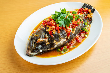 Braised grouper in a dish Chinese dish on wooden table