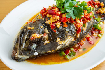 Braised grouper in a dish Chinese dish on wooden table