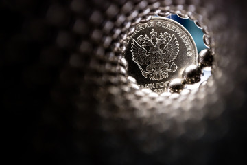 out-of-focus view from a spiral smelt pipe, at the end of a metal ruble coin