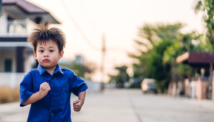 Portrait of cute little asian boy relaxing playing and having fun running  in city park