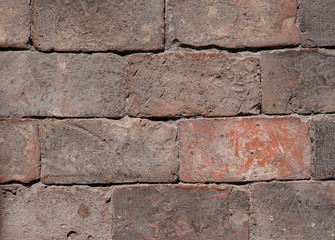 a wall of old, weathered bricks