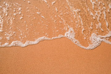 Tourist travel banner design template, copy space. White foam of a sea wave, golden sand beach, turquoise ocean water.