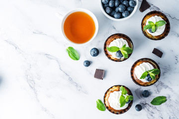 Chocolate cream cheese cupcakes with whipped cream, mint leaves and blueberry