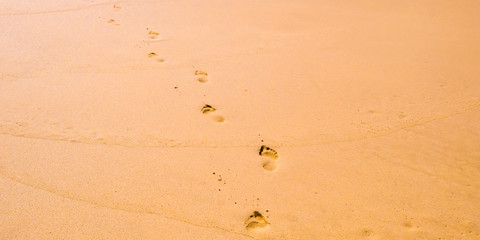 Foot prints on a sandy beach. Summer holidays concept, summer time. Empty beach with footprints.