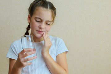 Cute teen girl suffers from tooth sensitivity and toothache after cold water