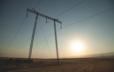 Power line at the sunset. High voltage tower