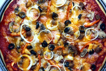 Freshly made pizza with cheese, tomato sauce, vegetable and meat toppings