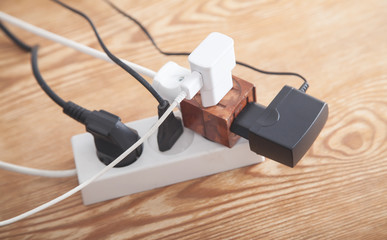 Different electrical plugs and chargers connected extension block.