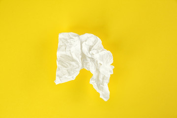 Used paper tissue on yellow background, top view