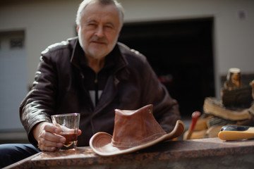 Glass with whiskey in hand of elderly man