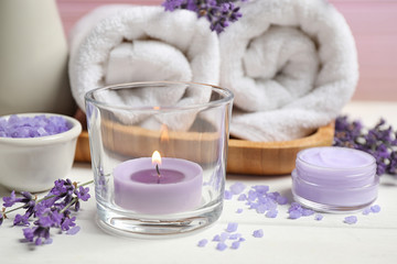 Cosmetic products and lavender flowers on white wooden table, closeup