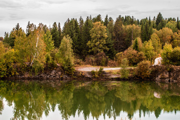 Fototapeta na wymiar Stunning photo of fall foliage reflected on a lake with a glass like mirror water surface