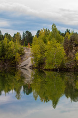 Stunning photo of fall foliage reflected on a lake with a glass like mirror water surface