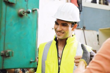 Engineering man talking with his partner in factory.