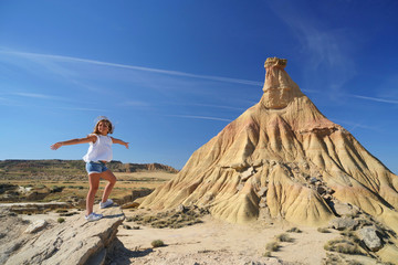 Naklejka premium Young girl standing by Castildetierra, Bardenas Reales National Park