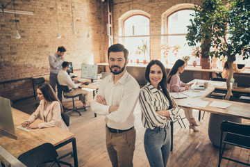 Photo of handsome business man pretty lady people two partners standing back-to-back spacious big office arms crossed members best friends successful teammates professionals indoors