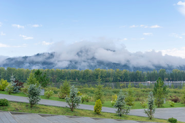 Mountain shrouded in thick fog in cloudy weather.