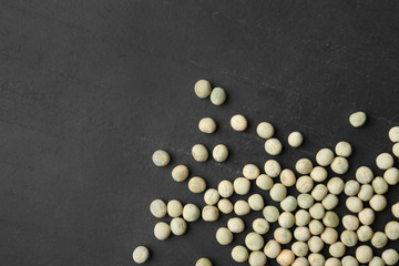 Raw dry peas and space for text on black background, flat lay. Vegetable seeds