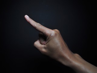 Male hand pointing isolated on black background. Body part gesture