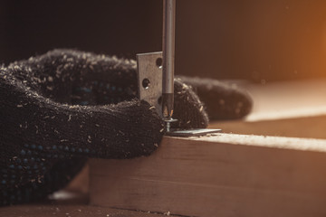 Home repair concepts, close up. Handicraft Carpentry. Cabinet-maker hands drilling a wooden plank...