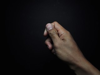Male hand holding virtual card with fingers isolated on black background