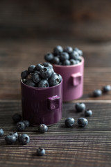 Blueberries in a cup on a wooden table