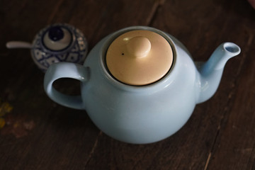 top view cream and blue colour teapot on wooden floor background