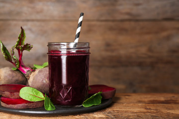 Freshly made beet juice on wooden table. Space for text