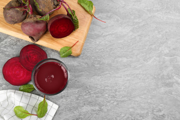 Freshly made beet juice on grey table, flat lay. Space for text