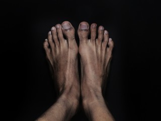 Close-up male feet isolated on black background