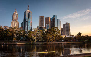 Fototapeta premium Cityscape and skyline of Melbourne. Man exercising in the city. A river in an urban environment with beautiful colors. 