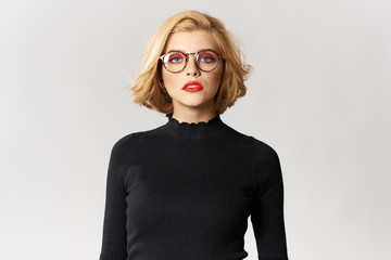 Blonde girl with glasses red lips black blouse cropped view glamor light background studio