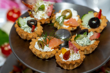 A variety of cold snacks on the table at parties, stuffed baskets with cheese and vegetables