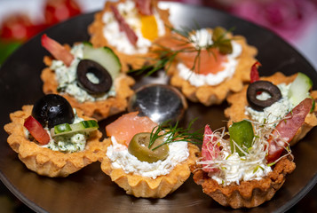 A variety of cold snacks on the table at parties, stuffed baskets with cheese and vegetables