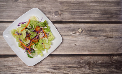 Colorful fresh vegetable salad on wood table.