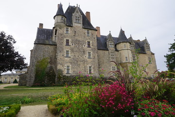 Fototapeta na wymiar old stone castle of the Roi René-Baugé in France with colorful flower beds
