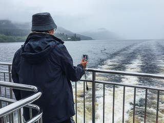 Persona haciendo fotos en el lago Ness
