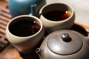 Chinese tea ceremony. Ceramic teapot made of clay and bowls on a wooden background.