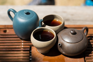 Chinese tea ceremony. Ceramic teapot made of clay and bowls on a wooden background.
