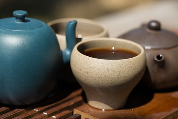 Chinese tea ceremony. Ceramic teapot made of clay and bowls on a wooden background.