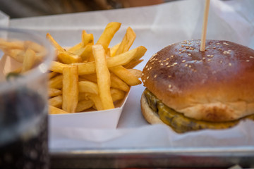 Isolated close up of a tray with fresh french fries, hamburger and a glass of coke- Israel