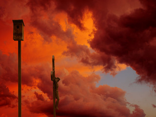 Dramatische Wolken, Himmel, Kruzifix und Vogelhaus