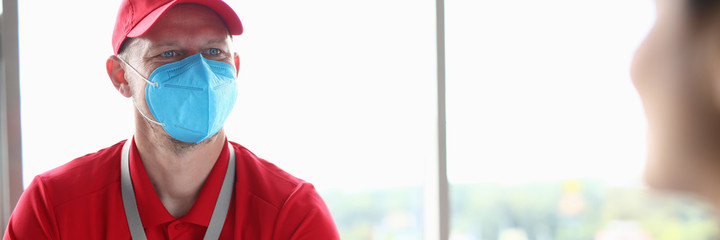 Masked man courier brought office documents. Contactless safe delivery of packages in coronovirus concept