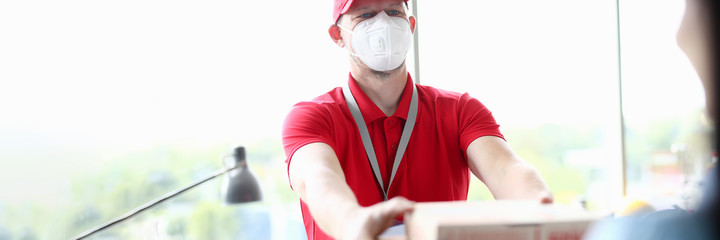 Courier in medical mask delivering pizza. Safe food delivery in coronovirus concept