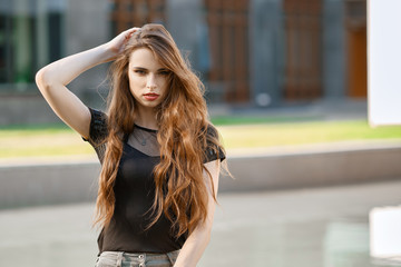 Positive young woman with long curly hair outdoor