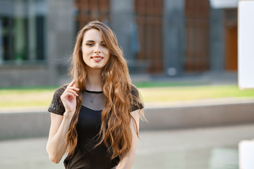Fototapeta premium Positive young woman with long curly hair outdoor